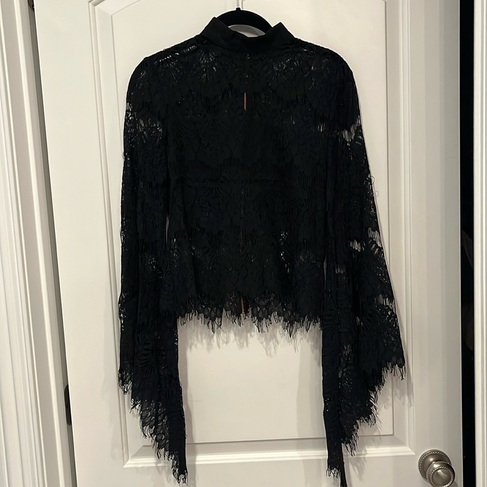 Black lace blouse with rose gold back zipper, bell sleeve, and raw lace hem